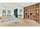 Bright living room featuring a large shelving unit, hardwood floors, and modern fireplace at 401 Lynne Cir, Alpharetta, GA 30009