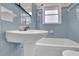Bathroom features blue tiling, tub with shower, and vintage fixtures at 1729 James Burgess Rd, Suwanee, GA 30024