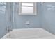 Bathroom features blue tiling and a bathtub with shower at 1729 James Burgess Rd, Suwanee, GA 30024