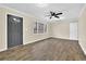 Open living room with sleek wood-look flooring, neutral paint, ceiling fan, and natural light at 1729 James Burgess Rd, Suwanee, GA 30024