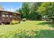 Lush backyard features a well-maintained lawn, mature trees, and a spacious deck, perfect for outdoor entertaining at 7215 Gresham Trce, Cumming, GA 30040