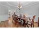 Formal dining room with hardwood floors, chandelier, and wainscoting, perfect for entertaining guests at 7215 Gresham Trce, Cumming, GA 30040