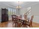 Formal dining room with hardwood floors, chandelier, and wainscoting, ideal for entertaining at 7215 Gresham Trce, Cumming, GA 30040
