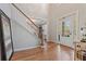 Elegant foyer featuring hardwood floors, staircase, and bright natural light from the front door at 7215 Gresham Trce, Cumming, GA 30040