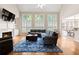 Inviting living room with fireplace, tall windows, and hardwood floors at 7215 Gresham Trce, Cumming, GA 30040