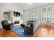 Bright living room with fireplace, built-in shelves, large windows, and hardwood floors at 7215 Gresham Trce, Cumming, GA 30040