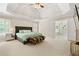 Large main bedroom with tray ceiling, plush carpet and ensuite bathroom at 7215 Gresham Trce, Cumming, GA 30040