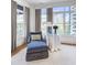 Bedroom space features a blue chaise lounge near large windows, with beautiful city views in the background at 2500 Peachtree Nw Rd # 606N, Atlanta, GA 30305