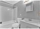 Tidy bathroom featuring a white tiled shower-tub, vanity, toilet, and new fixtures at 80 Holder St, Temple, GA 30179