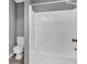 A bathroom with gray walls, a tub, and a toilet at 80 Holder St, Temple, GA 30179