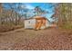Quaint home features inviting front porch with wooden stairs surrounded by a yard covered in fallen leaves at 80 Holder St, Temple, GA 30179