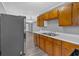 Kitchen flowing into living area showcasing stainless fridge, wood cabinets, and neutral walls at 80 Holder St, Temple, GA 30179