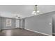 Open-concept living room with luxury vinyl flooring, a ceiling fan, and a charming chandelier at 80 Holder St, Temple, GA 30179