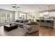 Bright living room with a gray sofa, large window, and an open floor plan flowing into the kitchen at 455 Timberleaf Rd, Canton, GA 30115