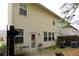 Rear exterior view of the home with a door leading to the patio area and grassy lawn at 5433 Cascade Sw Rdg, Atlanta, GA 30336