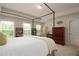 Bright primary bedroom boasts a four-poster bed, neutral walls, and a view of the greenery outside at 5433 Cascade Sw Rdg, Atlanta, GA 30336