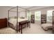 Spacious primary bedroom featuring a four-poster bed, neutral walls and carpet, and bookshelves at 5433 Cascade Sw Rdg, Atlanta, GA 30336