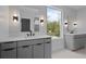 Bathroom featuring double vanities with marble countertops and modern fixtures, complemented by stylish lighting at 1186A Francis Nw St, Atlanta, GA 30318