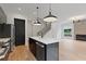 Open kitchen with stainless appliances, kitchen island with seating, open staircase, and fireplace in the living area at 1186A Francis Nw St, Atlanta, GA 30318