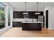 Modern kitchen with dark cabinets, stainless steel appliances, and a large center island with pendant lighting at 1186A Francis Nw St, Atlanta, GA 30318