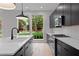 Modern kitchen featuring black cabinets, stainless appliances, white countertops, and a large window overlooking the yard at 1186A Francis Nw St, Atlanta, GA 30318
