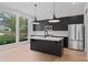 Modern kitchen featuring dark cabinets, an island, stainless appliances, and great natural light at 1186A Francis Nw St, Atlanta, GA 30318