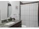 Modern bathroom with a granite countertop, round mirror, and shower with white curtain at 200 N Highland Ne Ave # 207, Atlanta, GA 30307