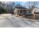 Charming home featuring a cozy porch with rocking chairs, with a newly paved concrete driveway at 100 Reed St, Canton, GA 30114