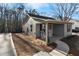 Side view of home featuring a covered porch with rocking chairs, and newly landscaped yard at 100 Reed St, Canton, GA 30114