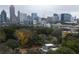 An aerial view of a neighborhood surrounded by trees, and the city skyline in the distance at 1186B Francis Nw St, Atlanta, GA 30318