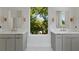 Stylish bathroom featuring dual sinks with modern fixtures, neutral cabinets, and a large window at 1186B Francis Nw St, Atlanta, GA 30318