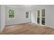 Light-filled bedroom showcasing hardwood floors, white trim, and views of lush greenery through expansive windows at 1186B Francis Nw St, Atlanta, GA 30318