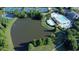 Aerial view of a neighborhood with lush trees, pool, tennis court, and serene lake for community enjoyment at 4050 Preserve Crossing Ln, Cumming, GA 30040
