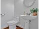 Powder room featuring a pedestal sink, a decorative mirror, and wood floors at 4050 Preserve Crossing Ln, Cumming, GA 30040