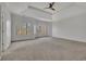 Spacious bedroom with neutral carpet, ceiling fan, and view of the outdoors at 4050 Preserve Crossing Ln, Cumming, GA 30040