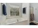 Bathroom featuring a soaking tub next to a large sunny window and a walk-in shower at 306 Blake Dr, Canton, GA 30114