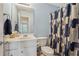 Bathroom with single vanity, toilet, and tub with blue and white shower curtain at 306 Blake Dr, Canton, GA 30114