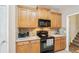 Kitchen features wood cabinets, black appliances, and light countertops at 306 Blake Dr, Canton, GA 30114