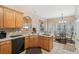 Eat-in kitchen boasts wood cabinets, stainless steel sink, black appliances, and a breakfast table set at 306 Blake Dr, Canton, GA 30114