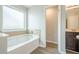 Bathroom featuring a frosted window over the tub and an open doorway to another bathroom at 920 Sublime Trl, Canton, GA 30114