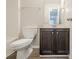 Bathroom featuring wood-look floors, toilet, and vanity with dark cabinets and a mirror at 920 Sublime Trl, Canton, GA 30114