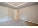 Bedroom featuring a tray ceiling, neutral walls, plush carpet, and two interior doors at 920 Sublime Trl, Canton, GA 30114