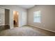 Bedroom featuring neutral carpet and trim, a large window, and access to bathroom at 920 Sublime Trl, Canton, GA 30114