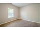 Bedroom featuring neutral carpet and trim, a large window, and light gray walls at 920 Sublime Trl, Canton, GA 30114