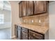 A view of the kitchen showcasing dark wood cabinets, stone countertops, and tile backsplash at 920 Sublime Trl, Canton, GA 30114