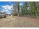 Large backyard with mature trees, a wooden deck, and a chain-link fence at 470 Oriole Dr, Marietta, GA 30067