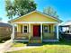 Charming yellow house with a cozy front porch, red door, and well-maintained lawn at 718 Dalvigney Nw St, Atlanta, GA 30318