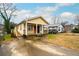 Inviting yellow home featuring a welcoming front porch and ample parking space at 718 Dalvigney Nw St, Atlanta, GA 30318