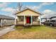 Attractive yellow home with a bright red door and a neatly kept front lawn at 718 Dalvigney Nw St, Atlanta, GA 30318