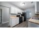 Efficient kitchen featuring white cabinets, butcher block countertops, and black appliances at 718 Dalvigney Nw St, Atlanta, GA 30318